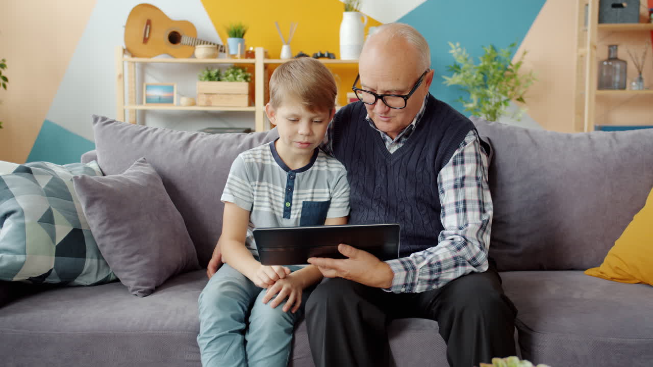 Grandfather and grandson using a tablet together