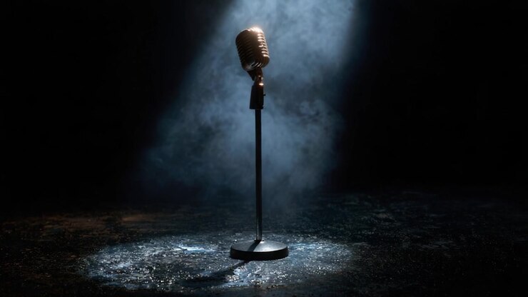 Un riflettore su un microfono classico: un simbolo iconico di performance ed espressione illuminato in un'ambientazione drammatica, che cattura l'essenza della musica dal vivo e della creatività