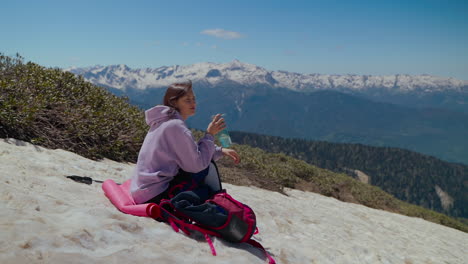 woman hiking in mountains enjoying a drink