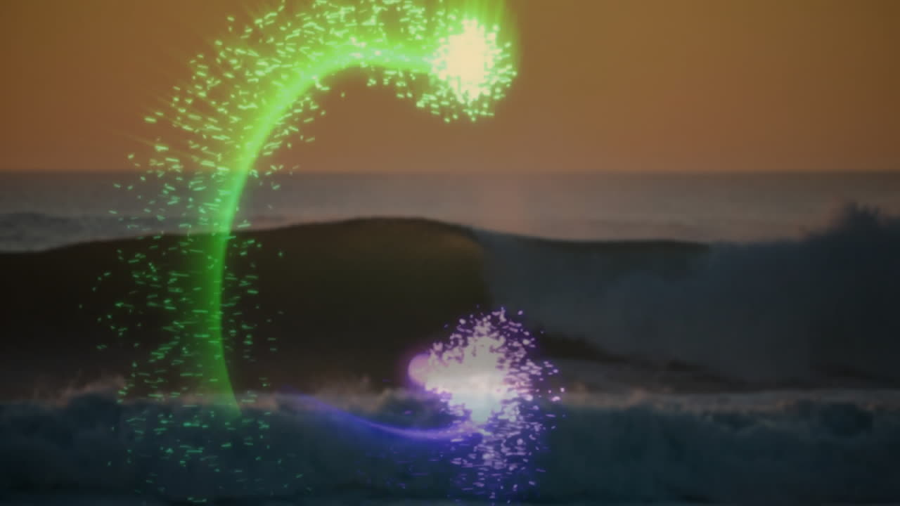 Animation of colorful light trails forming patterns over ocean waves at sunset