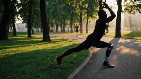 athlete with prosthetic leg stretching in a park