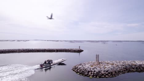 aerial follow of a motorboat leaving a dock near a shellfish farm in sete, france