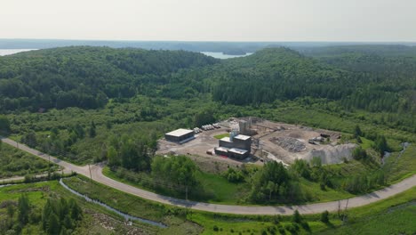 industrial ready mix plant surrounded by forest and a lake in muskoka, ontario. aerial flyover shot