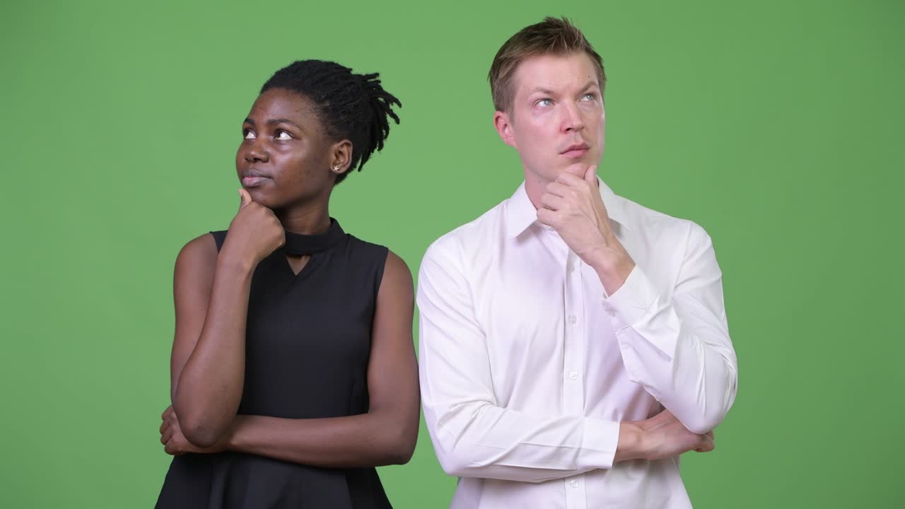 Two young multi-ethnic business couple thinking together