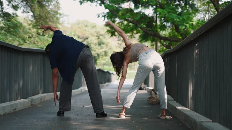 Couple Stretching Together in a Park
