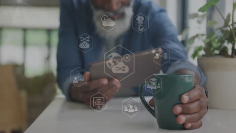 holding tablet, person with coffee cup viewing animation and digital icons floating
