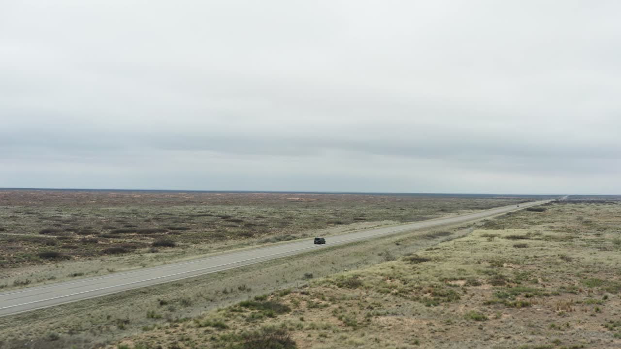 Car driving through majestic desert flatlands on asphalt highway