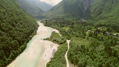 vista aérea del río soca rodeado de casas, colinas y naturaleza en eslovenia.