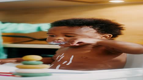 baby eating yogurt in highchair