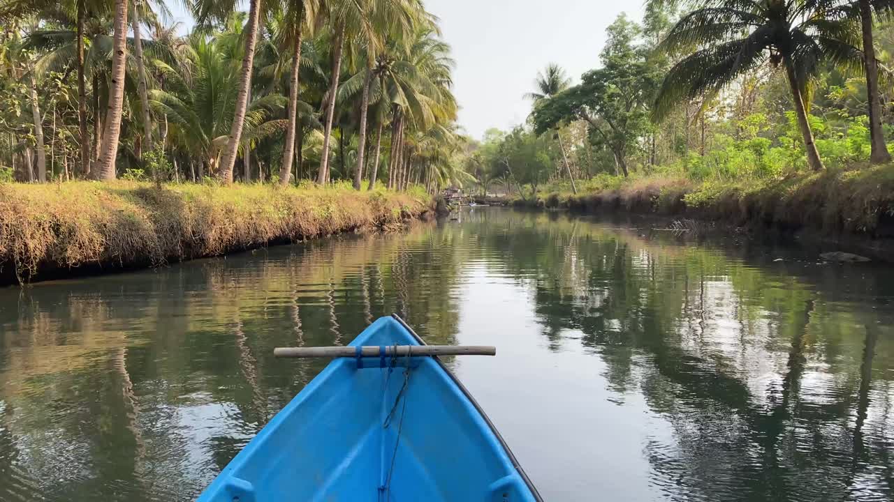 point of view in the boat seeing the scenery on the Cokel River in Pacitan, with the charm of the beauty of the calm river and many coconut trees.