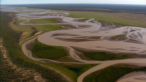 aerial view of a braided river system winding through a green landscape