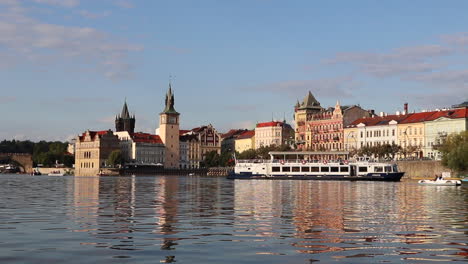 A-boat-on-Vltava-river-with-old-town-in-Prague,-Czech-Republic