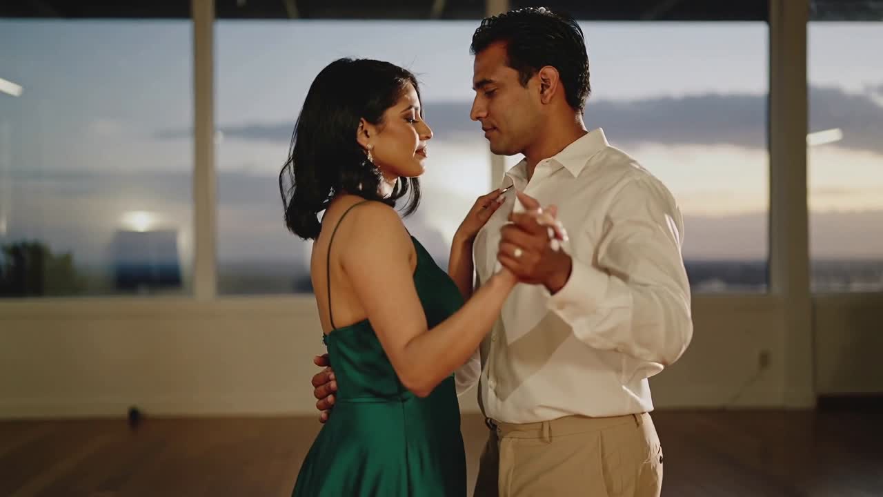 Coppia che si tiene stretta in uno studio di danza con finestre, l'uomo guida il movimento e fa apparire linee animate.