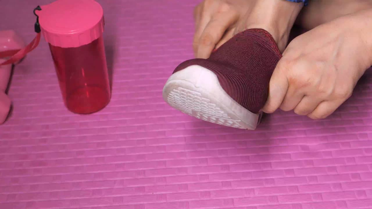 mujer vistiendo zapatos para una sesión de entrenamiento