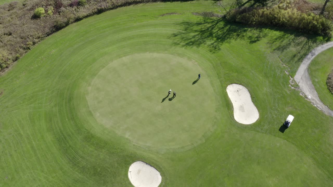 Drone footage of Golf Course. This is one clip of many in this series - each of which shows a different angle of the golf course and slightly different contents (greens - players) in the frame.