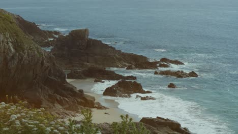 rocky coast in sunny weather where waves crash against the shore