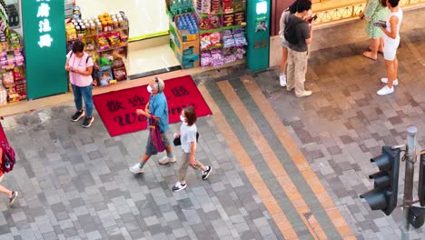 pedestrians stroll past a busy storefront