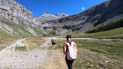 hikers in the ordesa valley overlooking monte perdido, huesca, pyrenees, spain