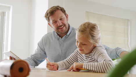 father helping daughter sitting at table with digital tablet home schooling during health pandemic