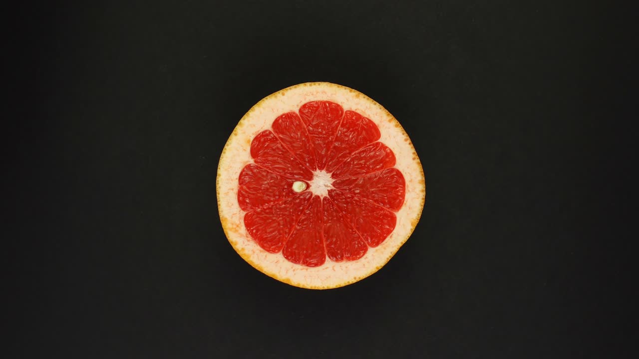 Fette rotonde, fresche e succose di pompelmo agrumato ruotano. Il concetto di alimentazione sana.