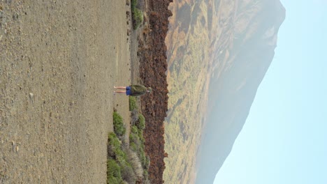 Lonely-boy-enjoys-rugged-volcanic-landscape-in-Tenerife,-Vertical