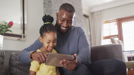 Feliz-Hija-Y-Padre-Afroamericano-Usando-Tableta-En-El-Sofá