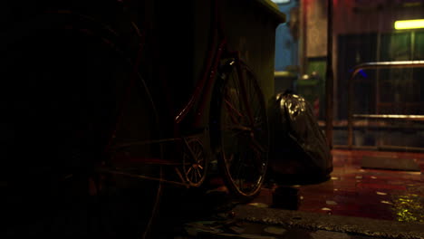 a rusty bicycle leans against a dumpster in a dark alley