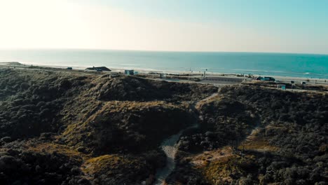 Coastal-ocean-road-aerial-view-panning-left-to-sandy-dune-terrain