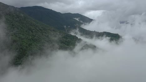 mountain landscape with clouds and fog, established aerial shot