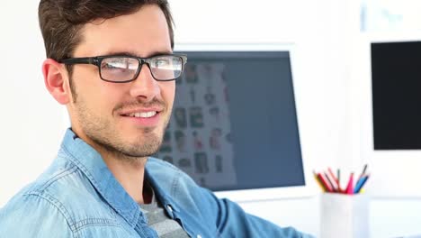 editor de fotos sonriendo en su escritorio