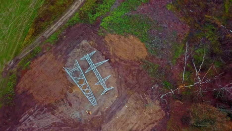 Drone-rotating-shot-over-assembling-of-electric-pole-for-placing-electric-lines-during-summer-day