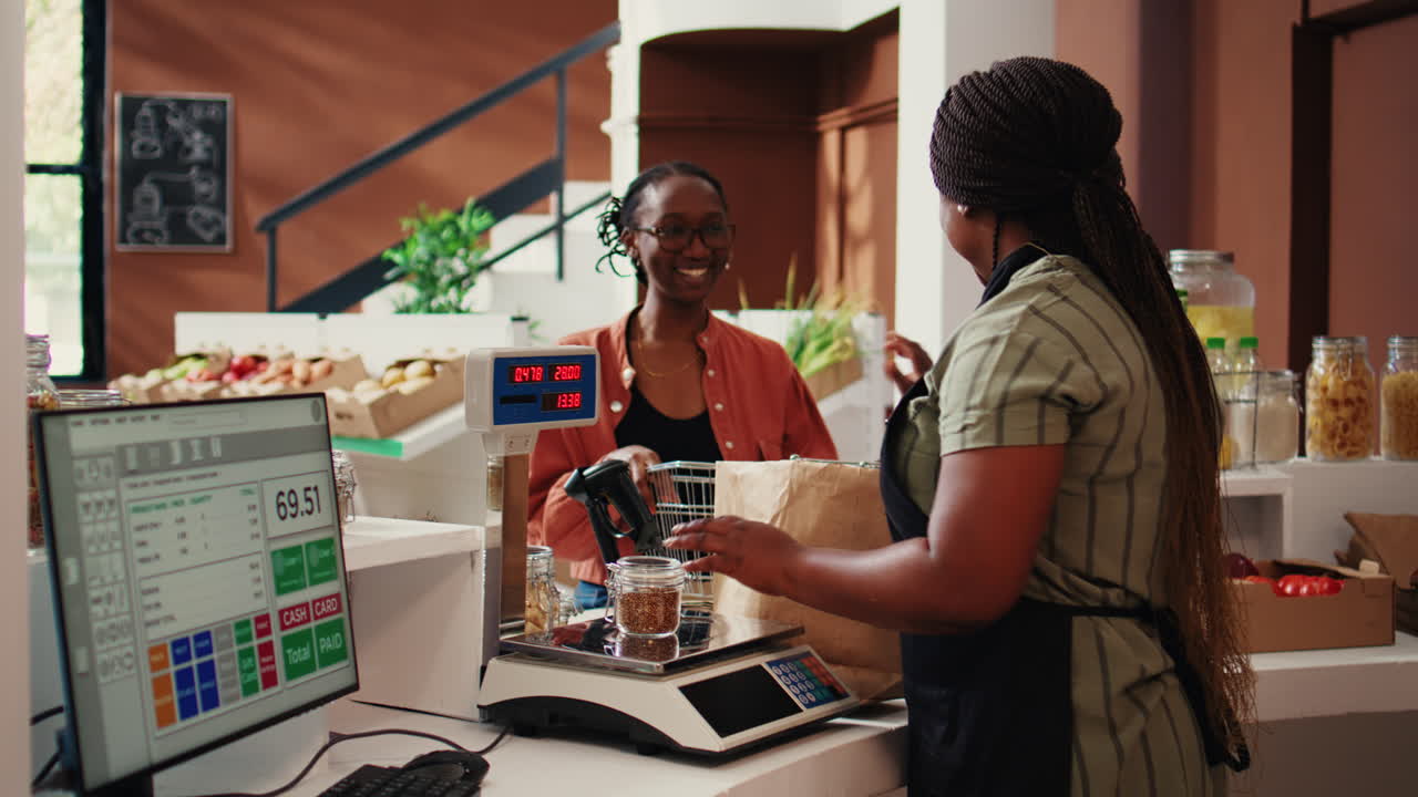 comerciante que pone todos los artículos en una balanza electrónica en la caja