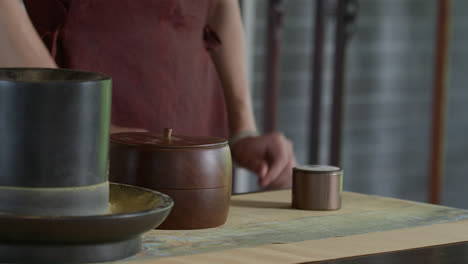 person covering a jar of tea after preparing the traditional tea-making ceremony