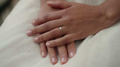 la novia muestra el anillo de bodas con las manos cruzadas