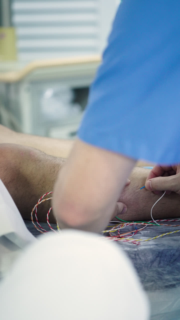 Nurse preparing a patient for surgery by placing electromagnetic sensors