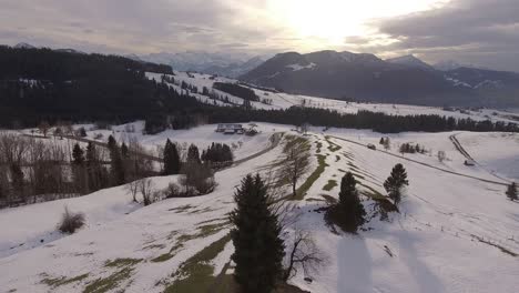 Beautiful-winter-panorama-in-Switzerland,-with-a-car-driving-on-a-curvy-road