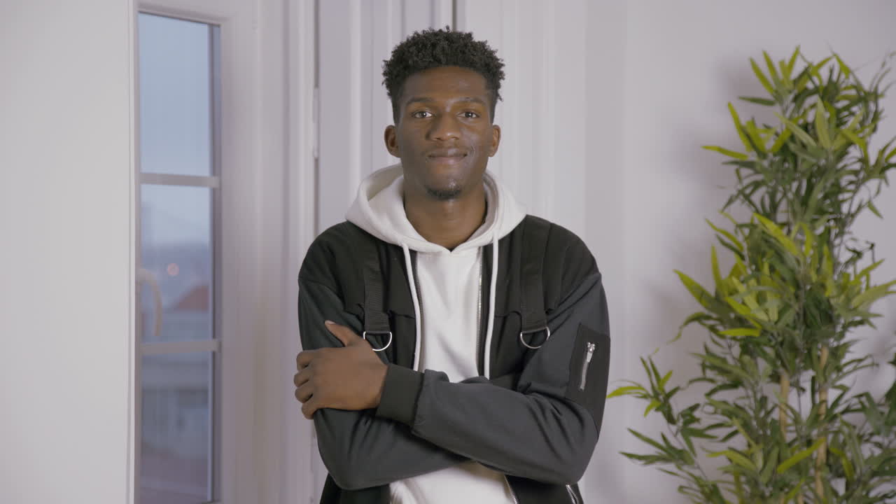 Retrato de um jovem sorridente de pé dentro de casa