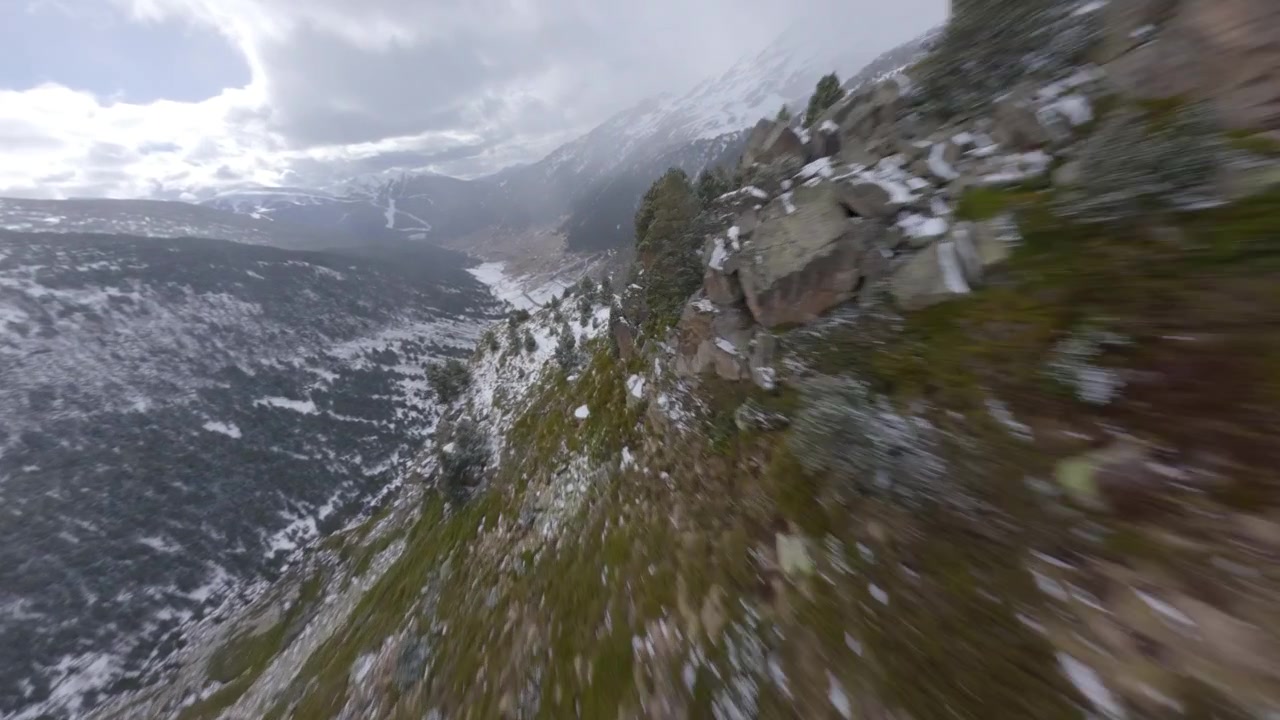 Drone FPV ad alta velocità che vola velocemente giù per le montagne innevate di Andorra, Valle de Incles