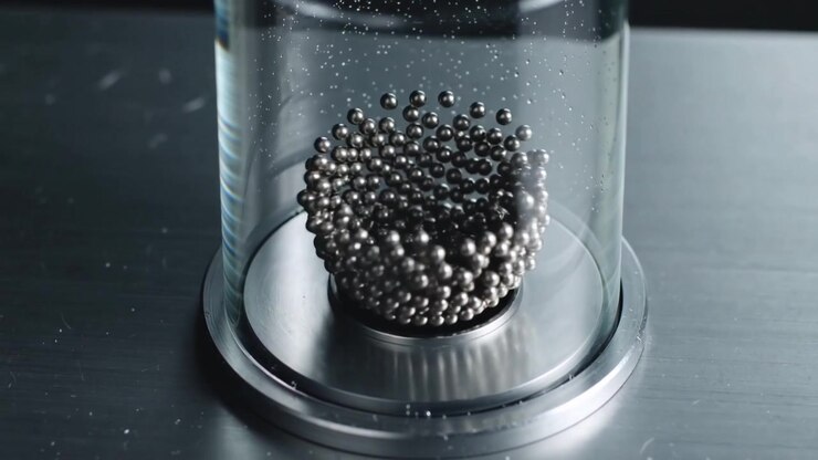 Shaking base sending steel balls spreading, rippling inside glass cylinder for testing