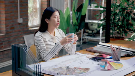 female designer working confidently workplace. cropped view of female designer making some sketches at a modern open space office. working with color swatch samples