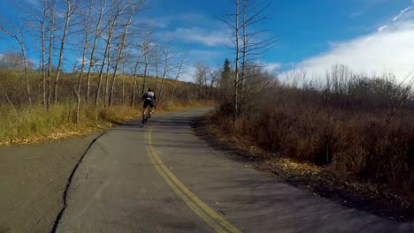 ciclista en bicicleta a través de una carretera de campo en el bosque 4k