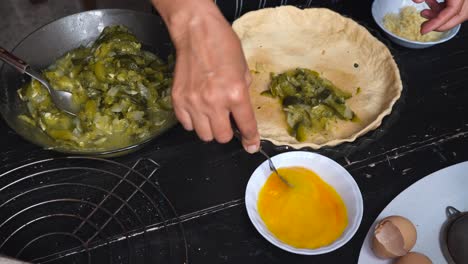 woman in the kitchen beating eggs for zucchini pie recipe