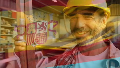 bandera española sobre el trabajador de la obra sonriendo.