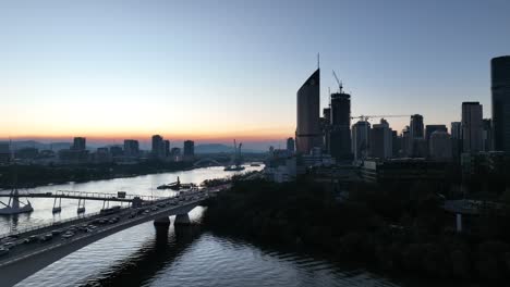 tracking drone shot off brisbane city, flying over brisbane river, captain cook riverside expressway bridge