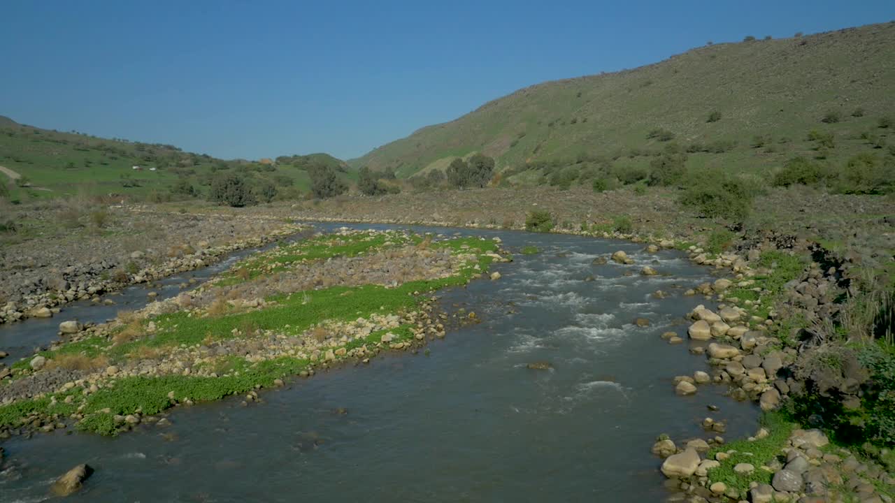 antena, río rocoso con rápidos en valle verde y colinas, cámara lenta