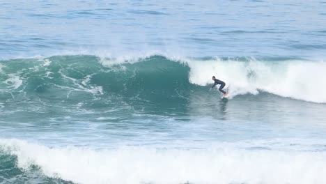 Surfer-making-a-single-bottom-turn-on-a-wave-in-guincho-surf-spot
