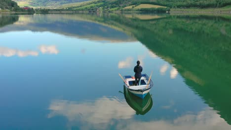 woman on the boat catches a fish on spinning in norway.