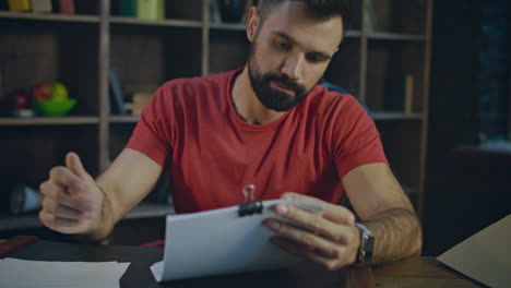 joven hombre de negocios leyendo documentos en la oficina. papeleo en la oficina por la noche