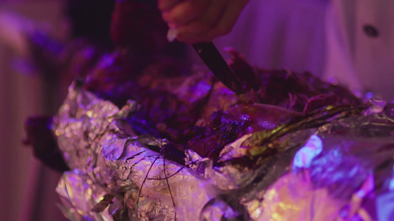 chef cortando cerdo recién horneado en la boda