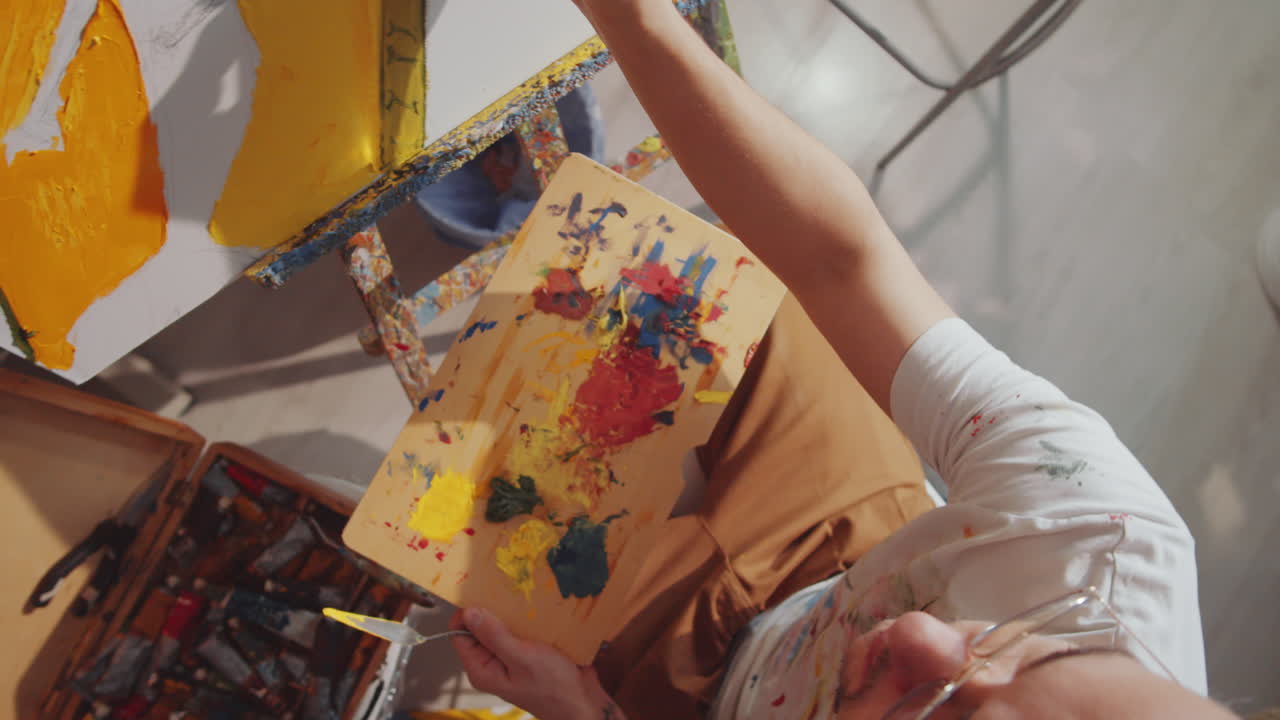 верхний вид мужского художника, рисующего картину в студии